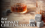 Whiskey stones and glass with liquor on a wooden table