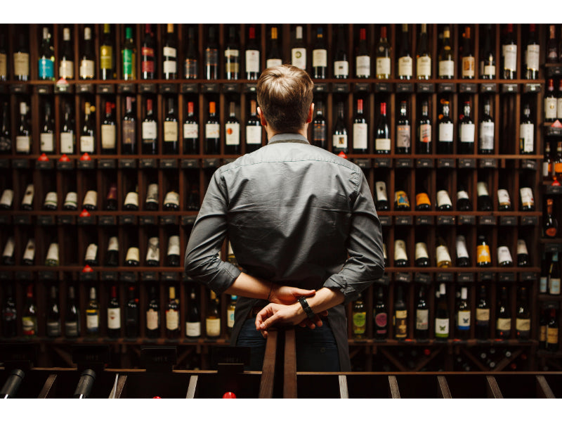 guy staring at a wine collection