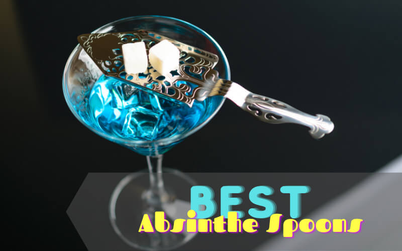 A cube of sugar on top of absinthe spoon and martini glass