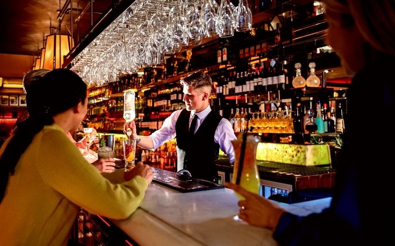 Bartender mixing a cocktail behind the bar