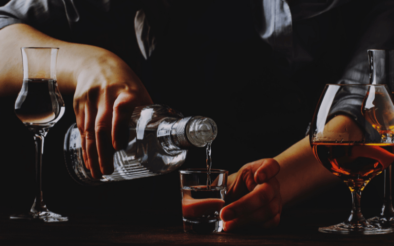 Bartender Pours the Vodka or Tequila in Small Shot Glass