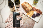 Coravin wine preservation system on a marble counter with bottles and charcuterie board